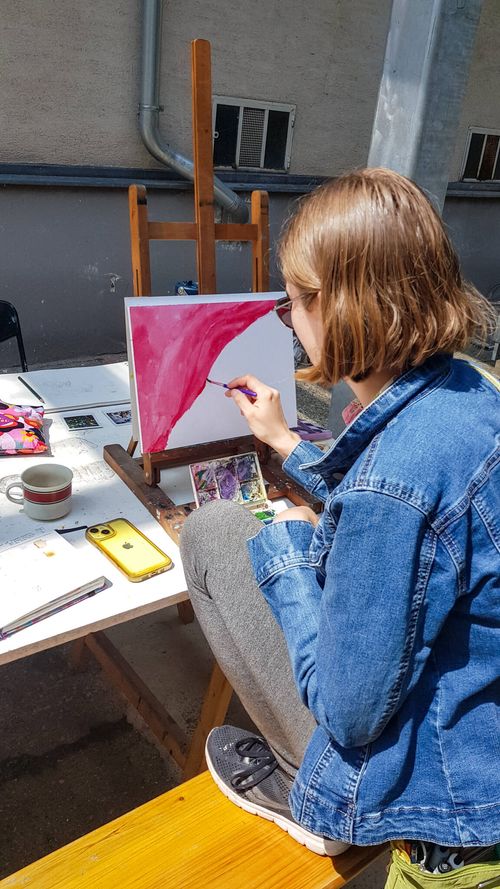 Students painting at easels in the studio