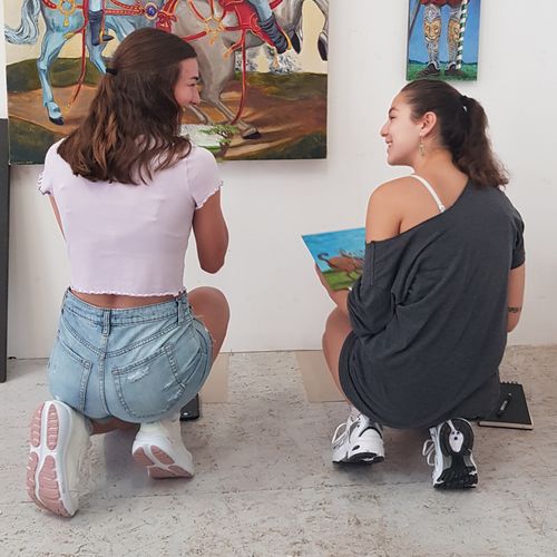 A photograph of two women discussing painting..